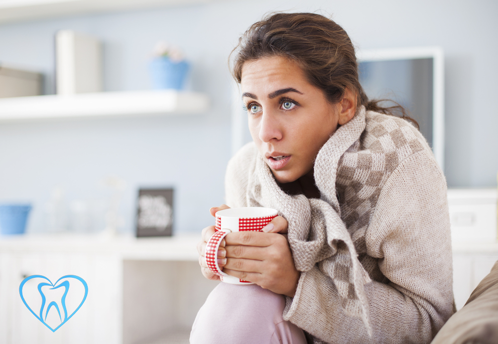 Woman under blanket with a cold.